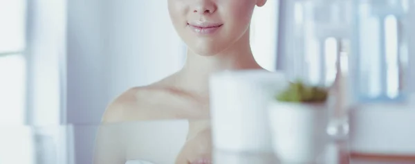Fiatal nő fürdőköpenyben nézi fürdőszoba tükör — Stock Fotó