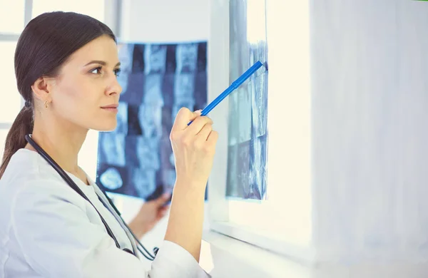 의사 사무실에서 엑스레이를 가리키는 청진기를 가진 젊은 웃는 여성 의사 — 스톡 사진