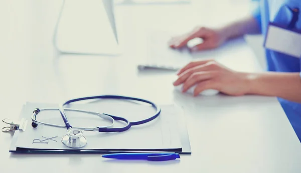 Doctora sentada en el escritorio y trabajando en un portátil en el hospital —  Fotos de Stock