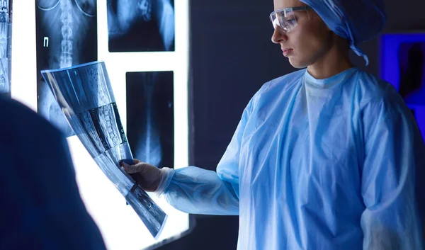 Зображення привабливої жінки-лікаря, який дивиться на результати рентгенівського випромінювання — стокове фото