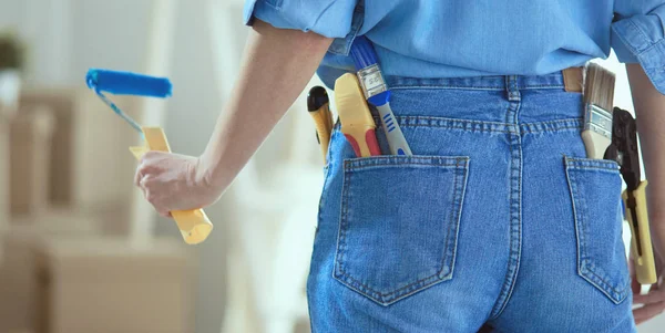 Pretty woman painting interior wall of home with paint roller — 스톡 사진