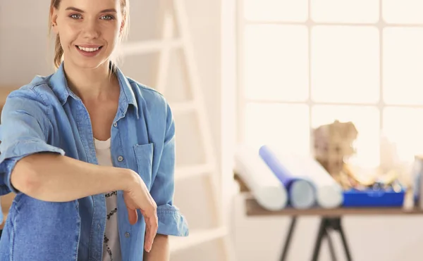 Jonge vrouw zit thuis en koopt nieuwe meubels via internet met behulp van een tablet computer — Stockfoto