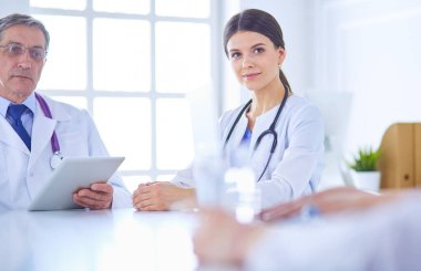 Doktorlar hastane konferans odasında birbirlerine danışıyorlar.