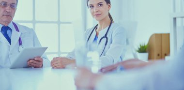 Doktorlar hastane konferans odasında birbirlerine danışıyorlar.