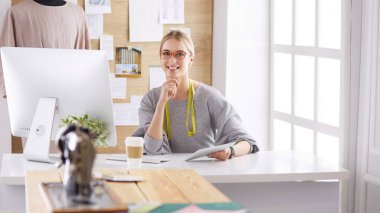 Masasında dikiş makinesi olan bir fabrikada genç ve güzel bir kız.