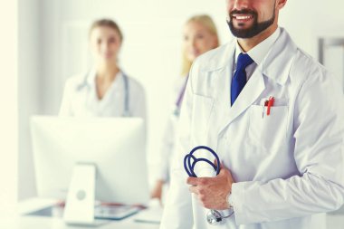 Tıbbi grubun önünde genç bir erkek doktor.