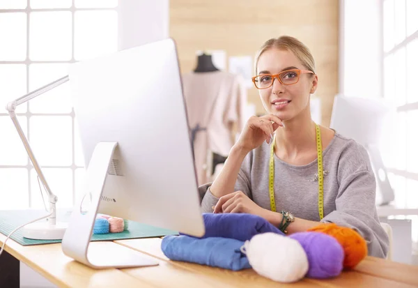 Fashion designer vrouw werken in de studio, zitten aan het bureau — Stockfoto