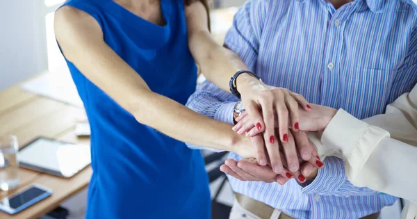 Geschäftskollegen stapeln sich im Büro die Hände — Stockfoto