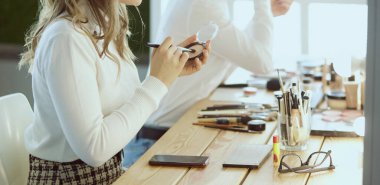 Makyöz, genç bir kadının profesyonel makyajını yapıyor.