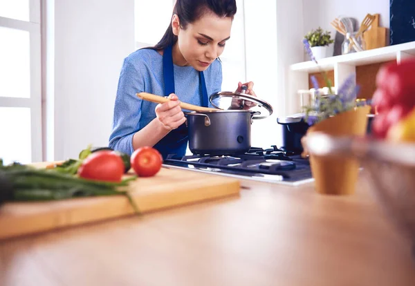 Cozinhar mulher na cozinha com colher de madeira — Fotografia de Stock