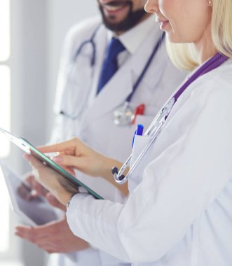 İki doktor bir dosya tutuyor ve hasta hakkında konuşuyorlar.