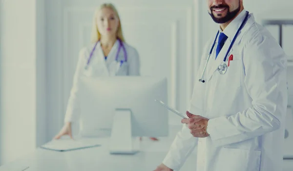 Equipo médico feliz de médicos, hombres y mujeres, aislados sobre fondo blanco en una habitación de hospital — Foto de Stock