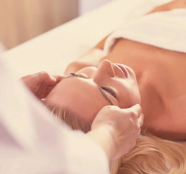 Jovem mulher desfrutando de massagem no salão de spa — Fotografia de Stock