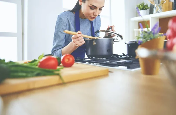 Cozinhar mulher na cozinha com colher de madeira — Fotografia de Stock