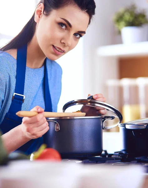 Cooking woman in kitchen with wooden spoon — Stock Photo, Image