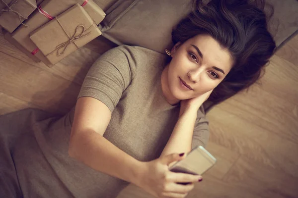 Visão superior de uma mulher usando seu telefone enquanto deitada de costas — Fotografia de Stock