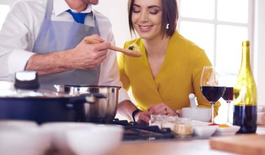 Evdeki mutfakta birlikte yemek pişiren çift.