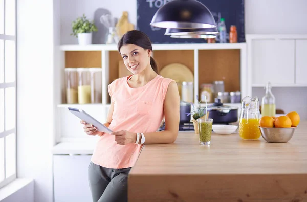 Gyönyörű fiatal nő használ egy digitális tabletta a konyhában — Stock Fotó