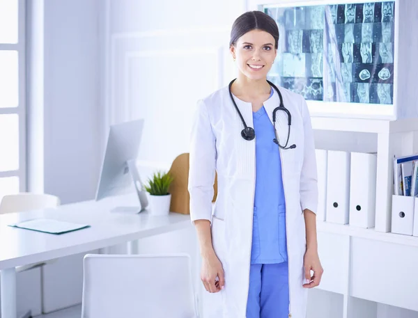 Ženský lékař stojící se stetoskopem a rukama v kapsách v nemocnici — Stock fotografie