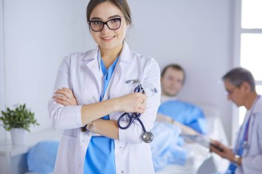 Kadın doktor hastanede steteskopla dikiliyor.