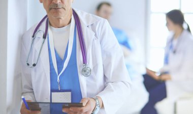 Doktor bir hastanın ve doktorun önünde klasörü tutuyor.