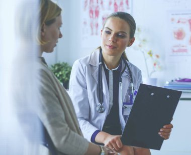 Doktor ve hasta masada otururken bir şey tartışıyorlar. İlaç ve sağlık hizmetleri kavramı