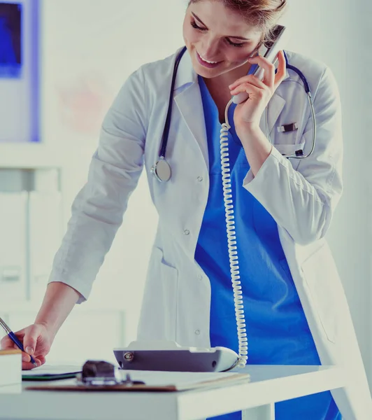 Serious doctor on the phone in her office — Stock Photo, Image