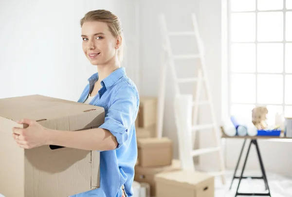 Mujer joven mudanza casa a casa nueva celebración de cajas de cartón — Foto de Stock