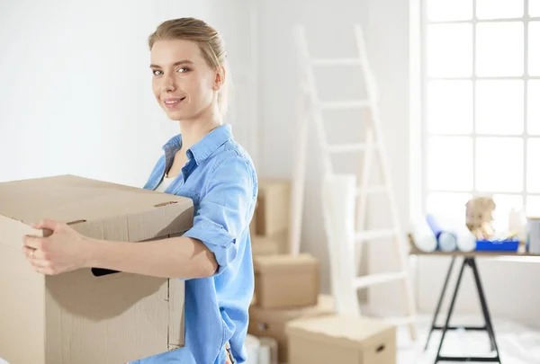 Mujer joven mudanza casa a casa nueva celebración de cajas de cartón —  Fotos de Stock