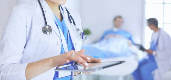 Жінка-лікар, що використовує планшетний комп'ютер у вестибюлі лікарні — стокове фото