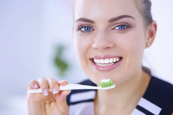 Joven chica bonita manteniendo la higiene bucal con cepillo de dientes . — Foto de Stock