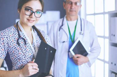 Bir doktor ekibi, kadın ve erkek, ofiste bekliyorlar.