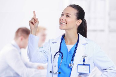 Masada oturan gülümseyen güzel genç bayan doktor.