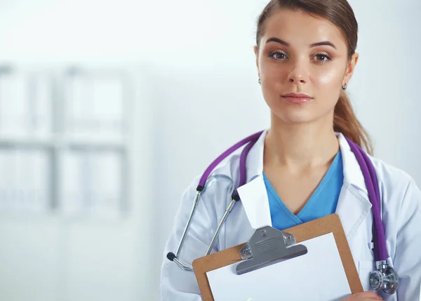 Dokter wanita berdiri dengan folder di rumah sakit — Stok Foto