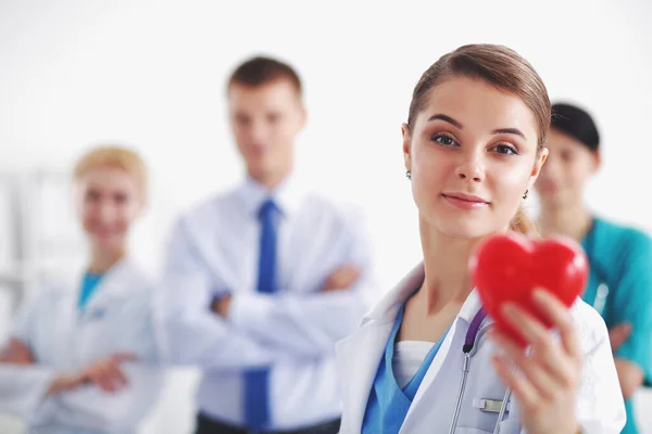 Ärztin mit Stethoskop hält rotes Herz — Stockfoto