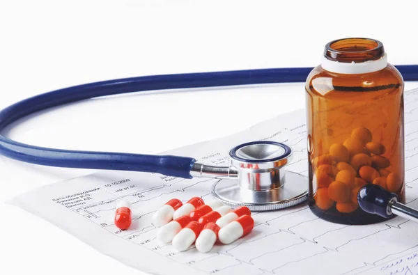 Bottles of pills and a medical stethoscope on white background — Stock Photo, Image