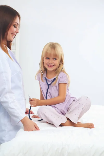 Médico femenino examinando a un niño con estetoscopio en cirugía. — Foto de Stock