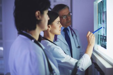 Bir grup doktor hastanede röntgenleri inceliyor.