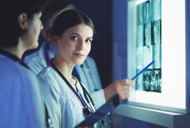 Bir grup doktor bir klinikte röntgenleri inceliyor, teşhis koymayı düşünüyorlar.