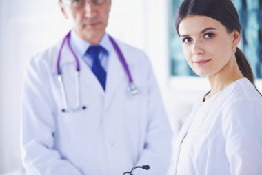 İki doktor hastanedeki konferans odasında, biri kameraya bakıyor.