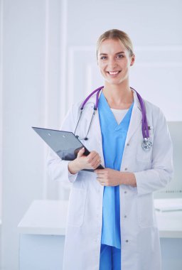 Kadın doktor hastanede dosyayla bekliyor.