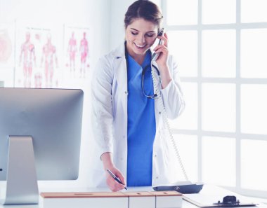 Telefonda konuşan gülümseyen güzel bir hemşirenin portresi.