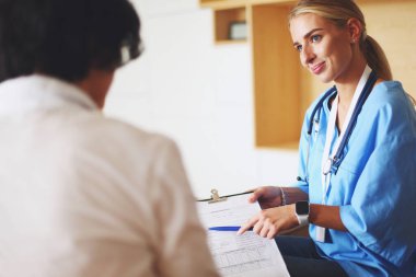 Kadın doktor, kadın hastasına teşhisi açıklıyor.