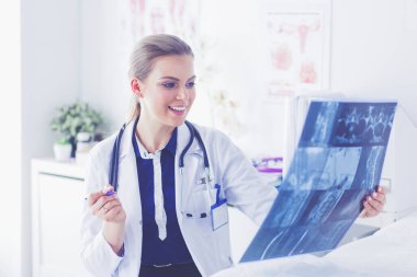 Genç ve çekici bayan doktor röntgen görüntülerine bakıyor.