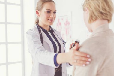 Doktor ve hasta masada otururken bir şey tartışıyorlar. İlaç ve sağlık hizmetleri kavramı