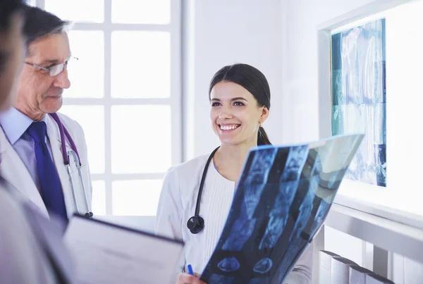 Lächelnde Ärzte diskutieren die Diagnose ihrer Patienten beim Röntgen im Krankenhaus — Stockfoto