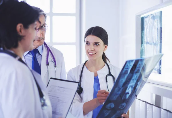 Médecins souriants discutant du diagnostic des patients regardant les rayons X dans un hôpital — Photo