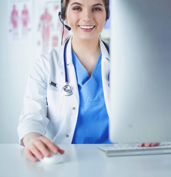 Jonge arts arts werkzaam bij de receptie van de kliniek, ze is het beantwoorden van telefoongesprekken en afspraken plannen — Stockfoto