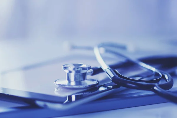 Lääketieteelliset laitteet: sininen stetoskooppi ja tabletti valkoisella pohjalla. Lääkintälaitteet — kuvapankkivalokuva
