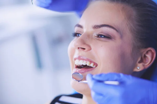 Mujer joven con la boca abierta examinando la inspección dental en el consultorio del dentista. — Foto de Stock